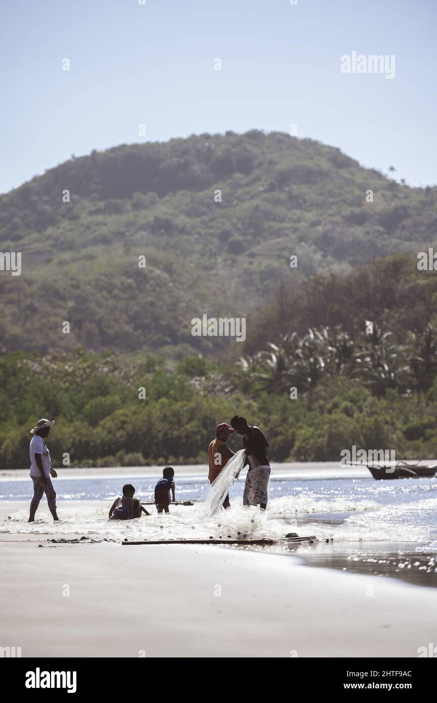 Un villaggio di pescatori filippino sulla costa con la gente del posto che pesca nell'oceano con le reti Foto Stock