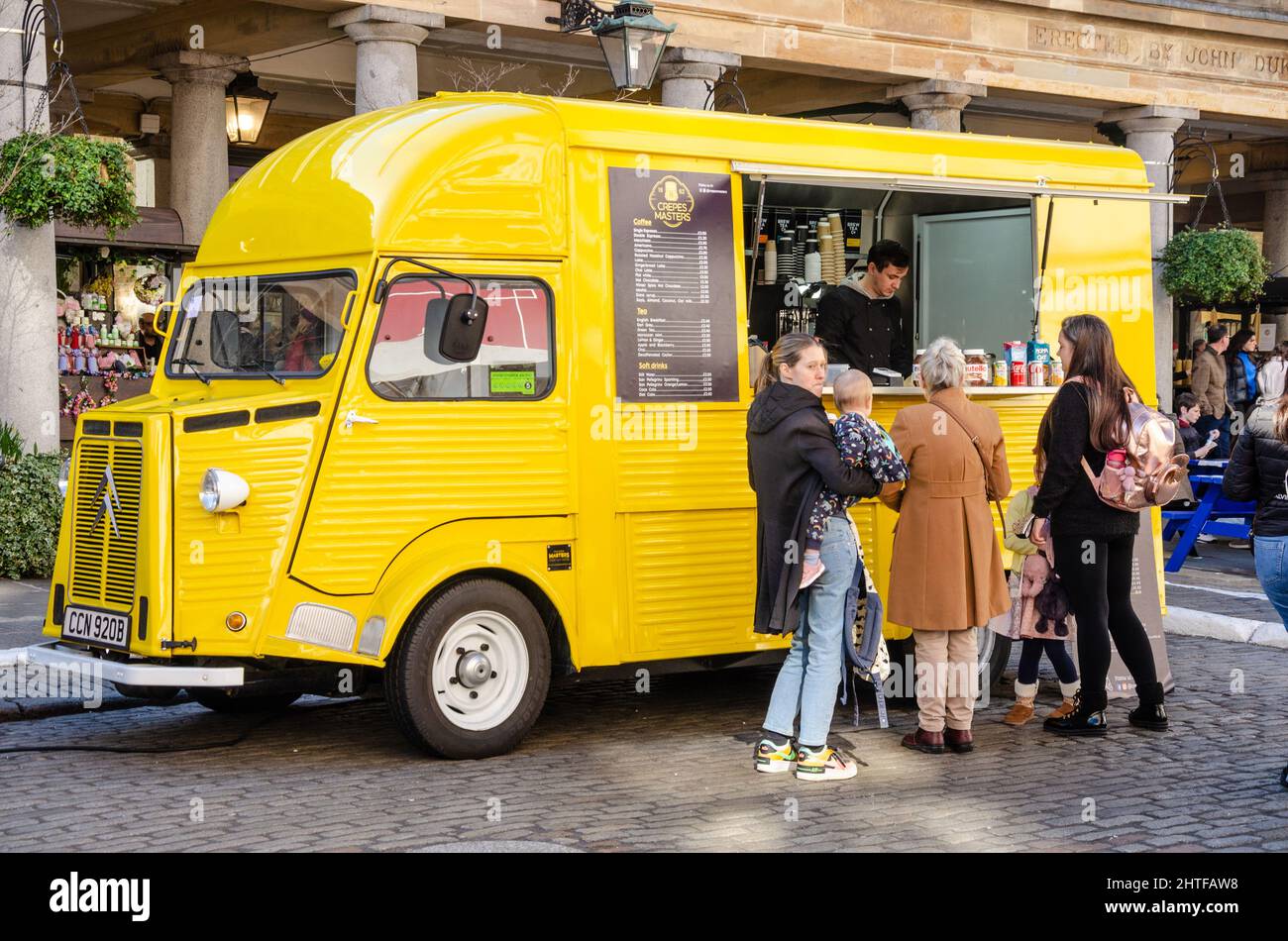 Un vecchio, giallo Citreon catering furgone con i clienti che acquistano cibo a Covent Garden a Londra, Regno Unito Foto Stock