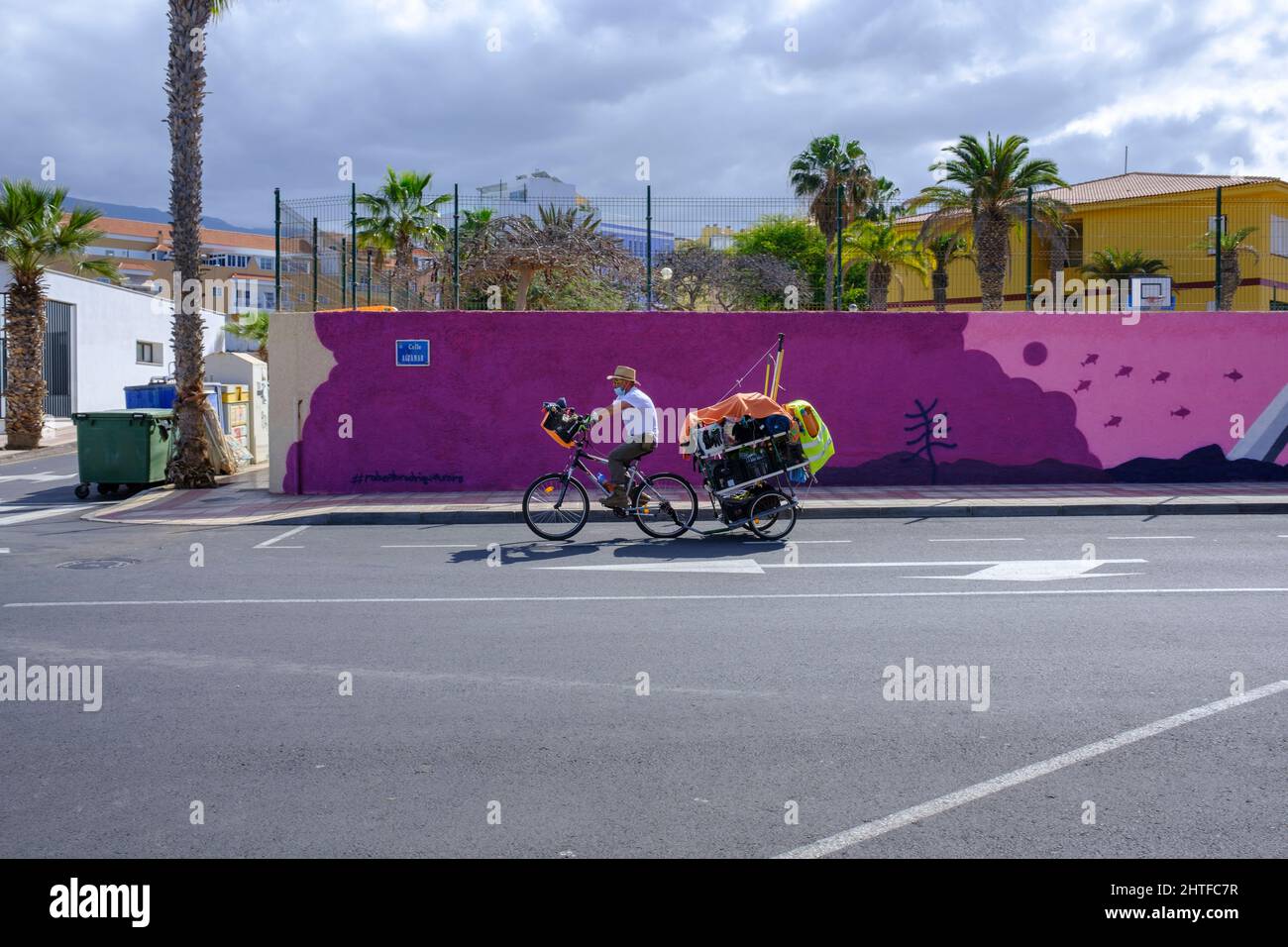 Il rimorchio per il traino di ciclisti passa davanti a un murale presso la scuola elementare locale di Playa San Juan, Tenerife, Isole Canarie, Spagna Foto Stock