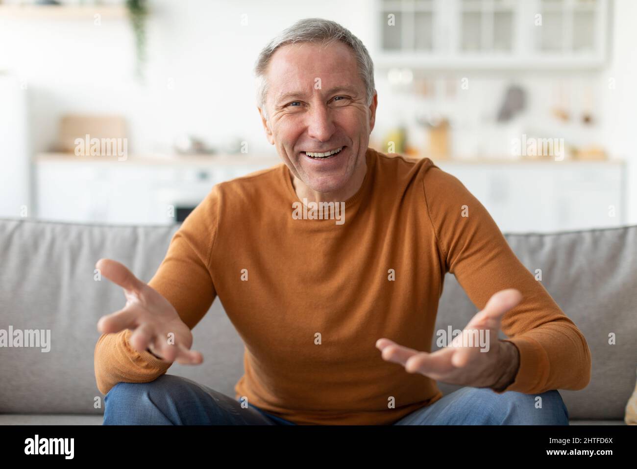 Uomo maturo che parla e gesturing alla macchina fotografica Foto Stock