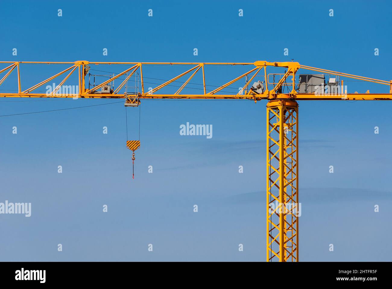 Industria edilizia e sviluppo. Gru gialla con gancio in funzione Foto Stock