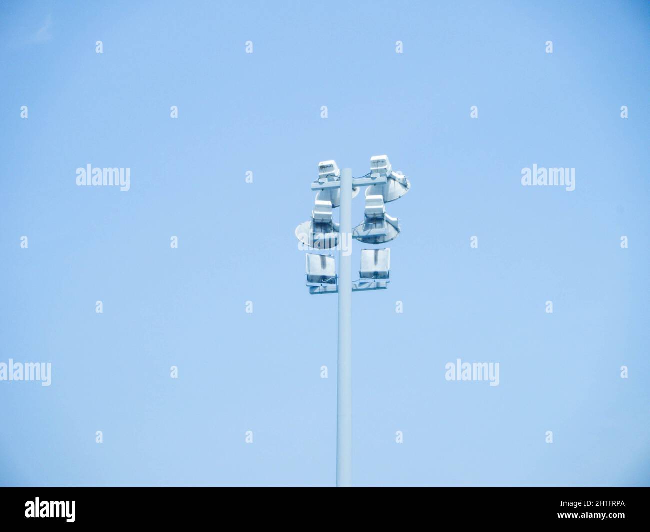 Una splendida vista di un palo di illuminazione in acciaio bianco freddo High Mast per autostrada con un cielo blu Foto Stock
