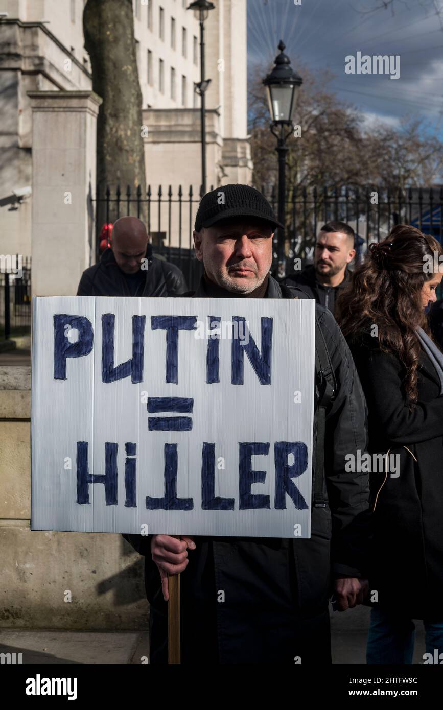 Il protestante che tiene Putin equivale alla targa Hitler, di fronte a Downing Street a Whitehall, Londra, Regno Unito Foto Stock