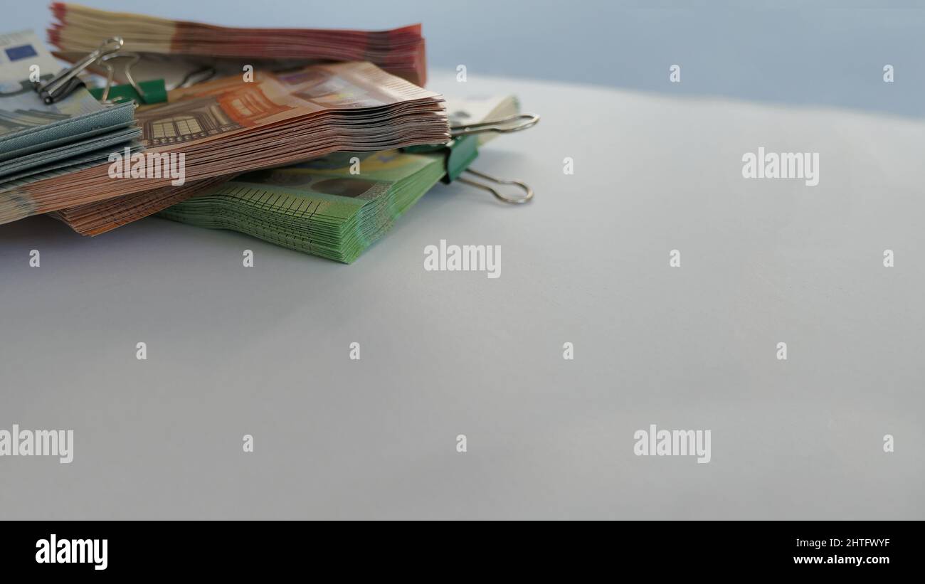 primo piano delle banconote in euro impilate da una clip pieghevole impilata in un angolo - sfondo bokeh Foto Stock