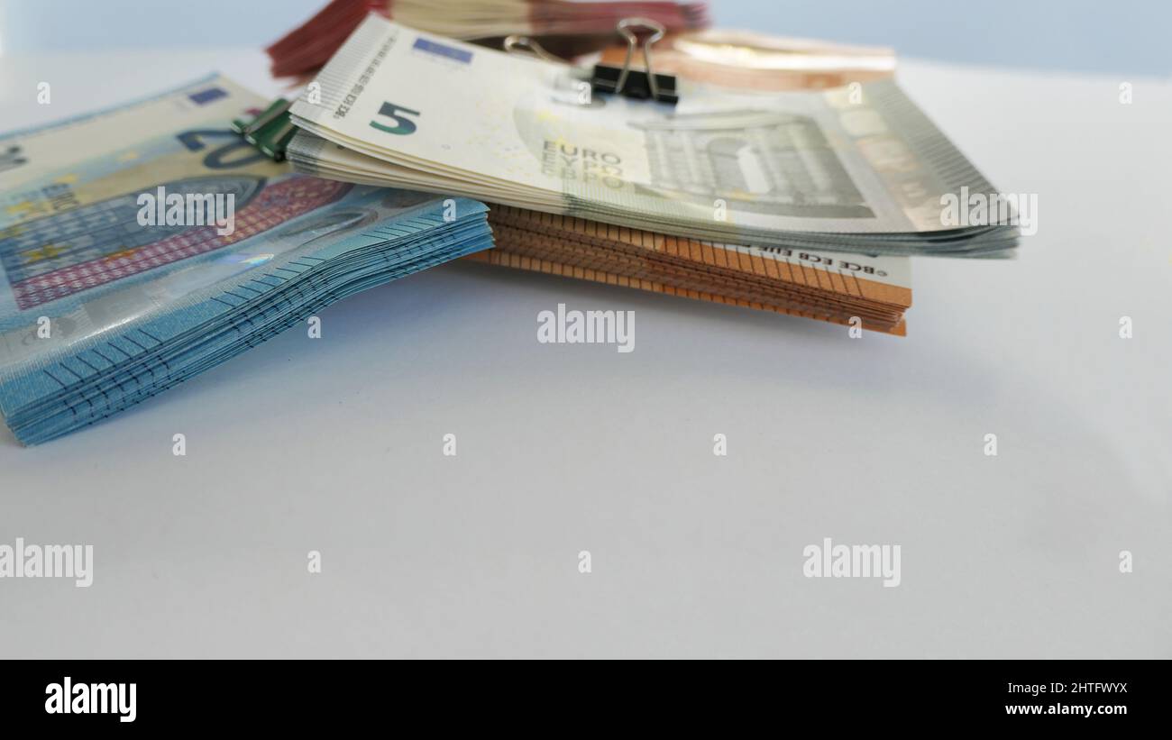 primo piano delle banconote in euro impilate da una clip pieghevole impilata in un angolo - sfondo bokeh Foto Stock
