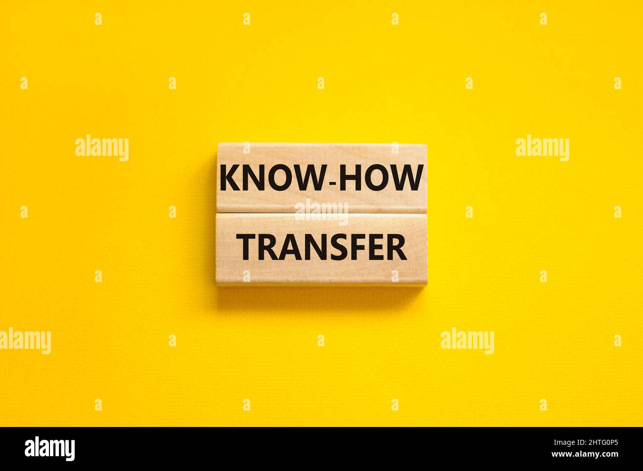 Simbolo di trasferimento del know-how. Concetto parole know-how trasferimento su blocchi di legno su bello giallo tabella sfondo giallo, spazio copia. Business, innovazione Foto Stock