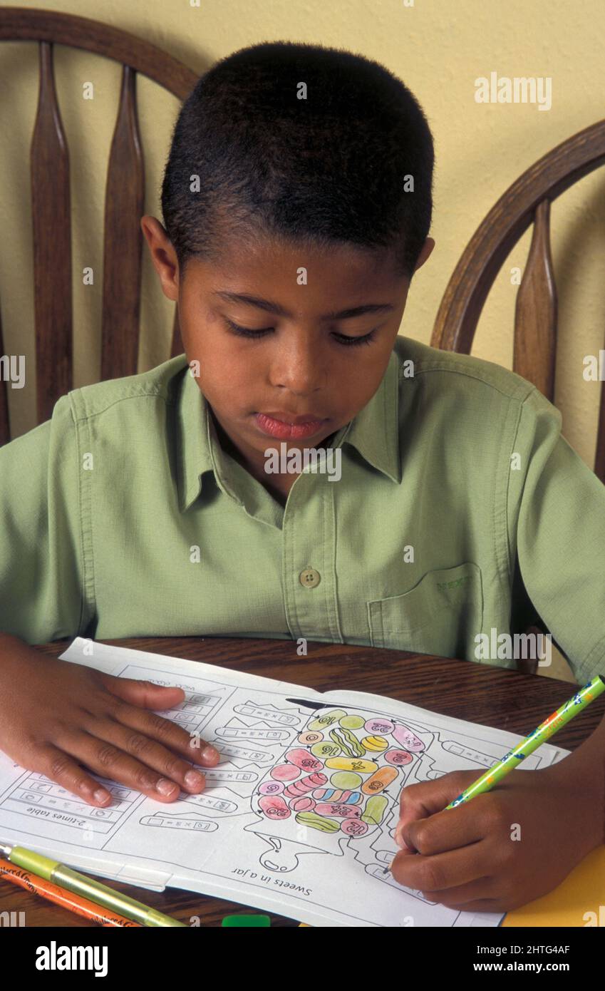 bambino nero giovane che fa i compiti di matematica Foto Stock