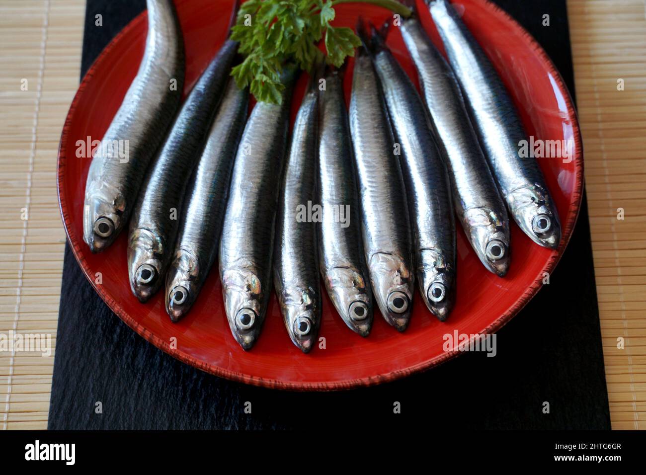 Pesce fresco di mare crudo sardine sul piatto, preparato per cucinare e fare un pasto Foto Stock