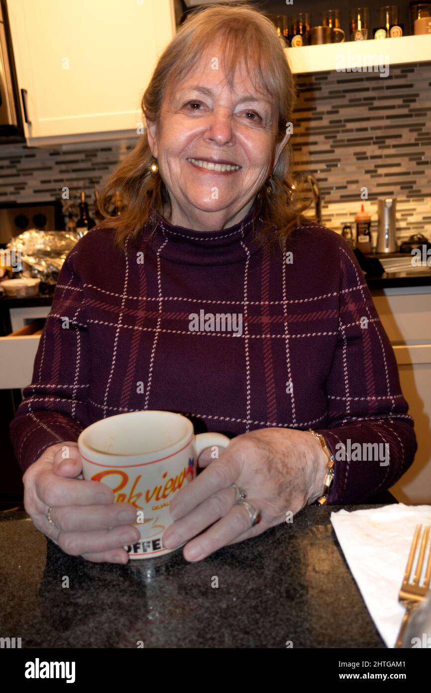 Bellissimo fotografo Mary Skjold che tiene una tazza di caffè sorridente in cucina. St Paul Minnesota, Stati Uniti Foto Stock