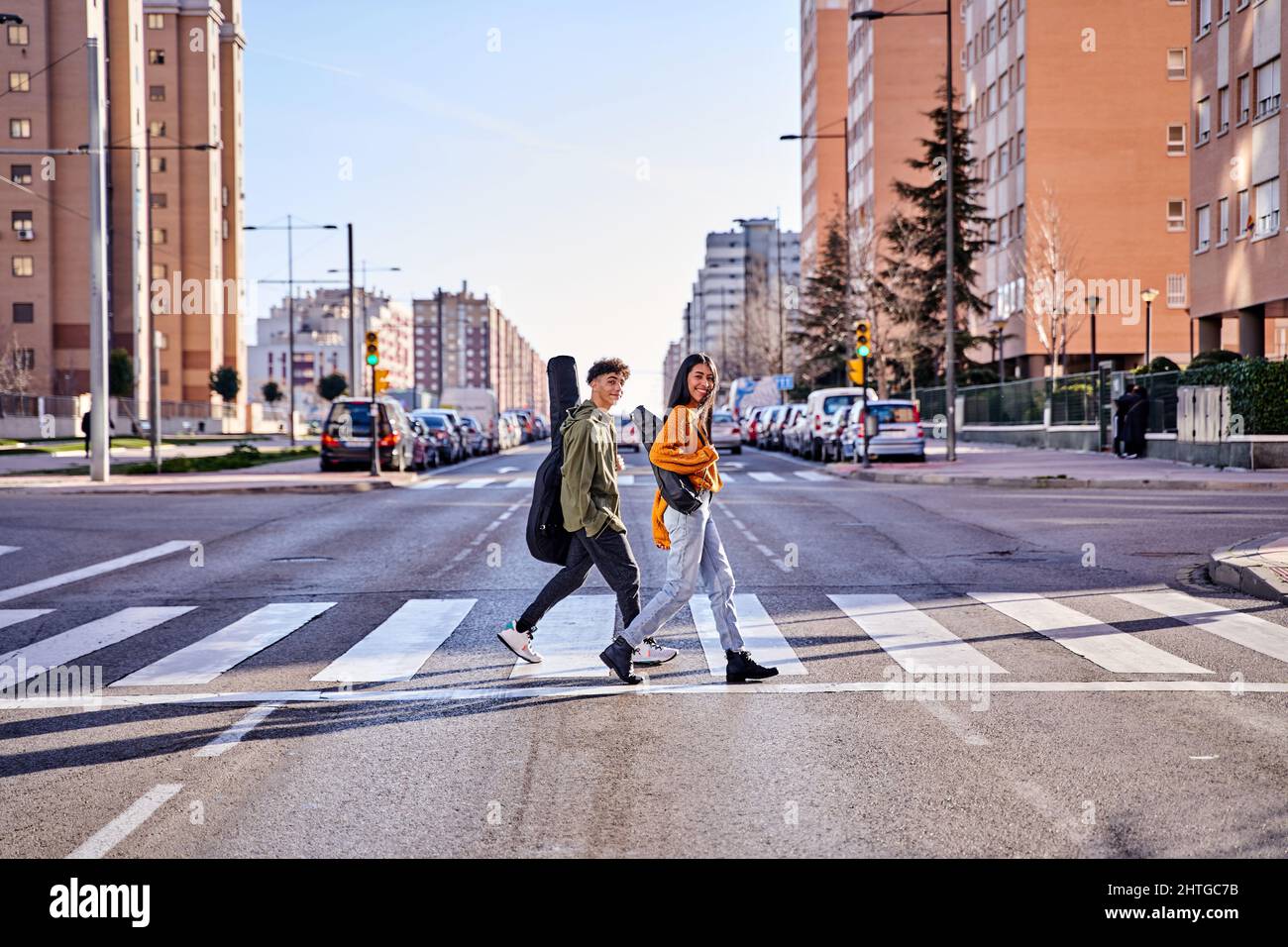 hipster adolescente stile di vita urbano. gli studenti di musica vanno a classe o ad un concerto. concetto di pedone attraversamento del traffico leggi e stile di vita Foto Stock