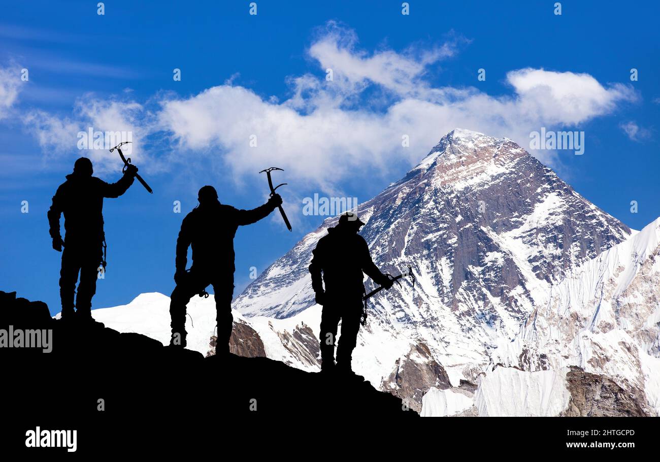 Monte Everest con silhouette nera di tre arrampicatori con ascia di ghiaccio in mano sulla strada per l'Everest campo base, valle di Khumbu Solukhumbu - Nepal Himalayas Foto Stock