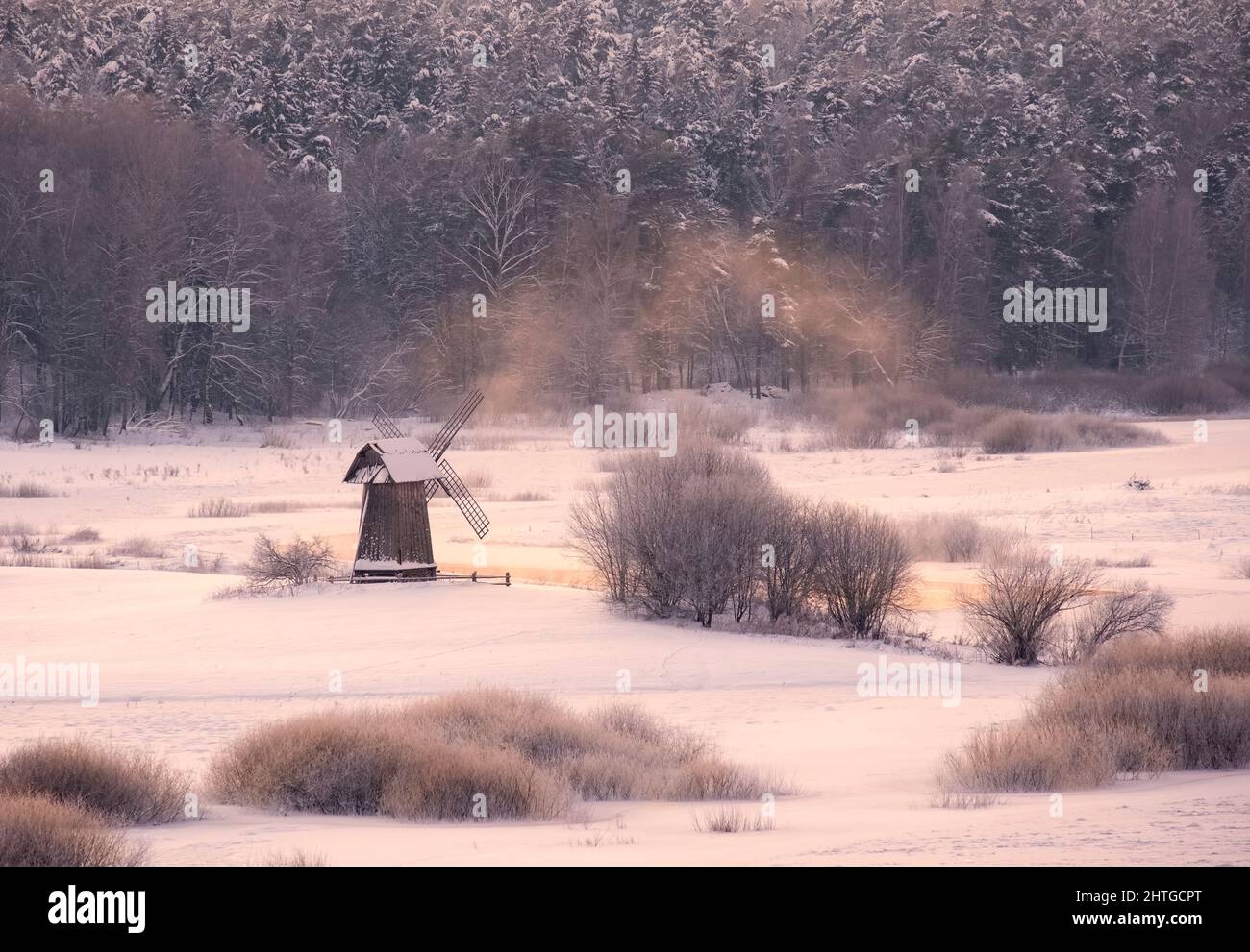 Fattoria di vilaggio di mulino a vento innevato in terra rurale d'inverno al giorno Foto Stock