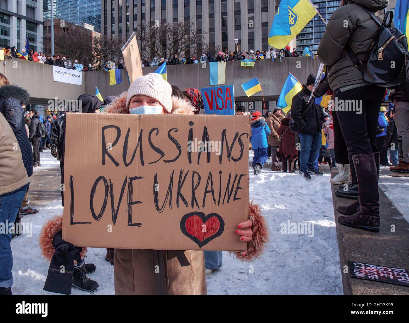 Toronto, Ontario/Canada - 27 febbraio 2022: Senior Lady of Russian Heritage tiene un cartello con scritto a mano Russian Love Ukraine nel mega marzo di Toronto e si raduna per sostenere l'Ucraina e condannare l'invasione di Putin. Foto Stock