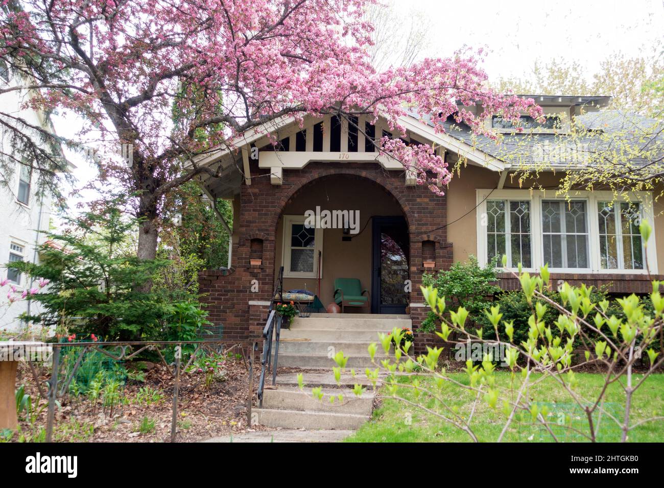 Bella casa di quartiere incorniciata con alberi e arbusti fioriti. St Paul Minnesota, Stati Uniti Foto Stock