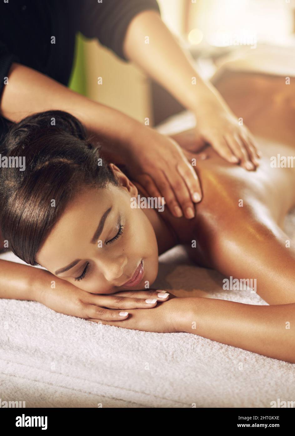Massaggiare il corpo e la mente. Scatto ad angolo alto di una giovane donna che riceve un massaggio al centro benessere. Foto Stock