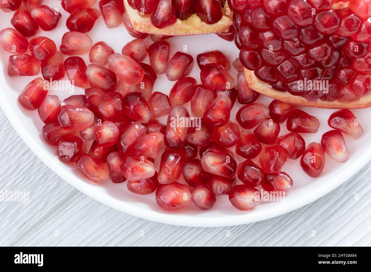 Semi di melograno sul piatto Foto Stock