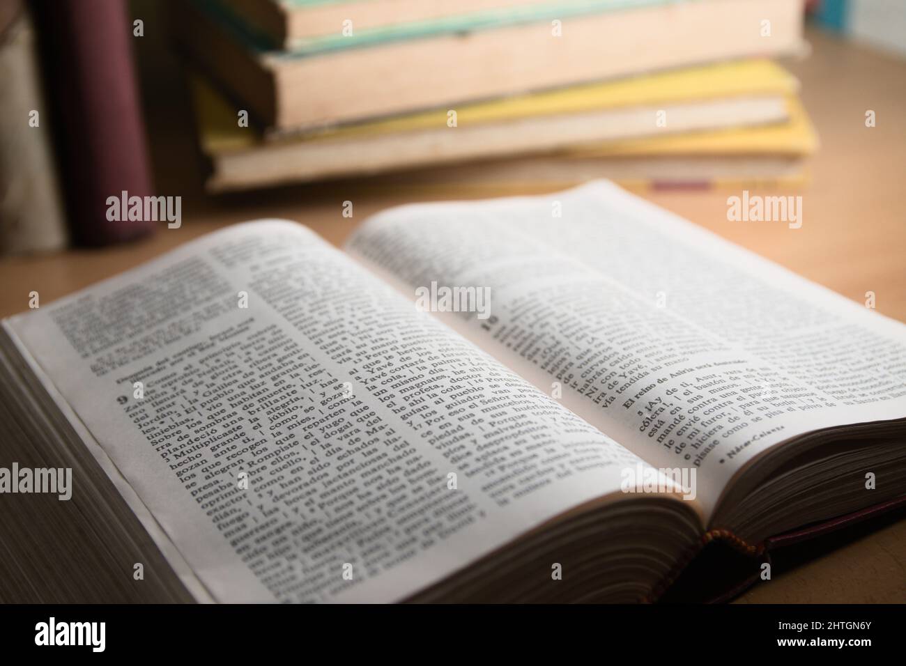 Primo piano di un libro di una bibbia su un tavolo su cui ci sono altri libri Foto Stock