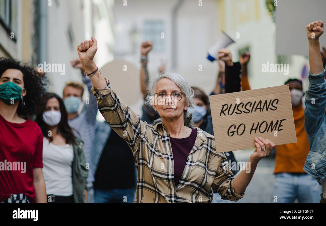Protesta contro l'invasione russa dell'Ucraina. Persone che tengono canti e striscioni anti-guerra in strada. Foto Stock