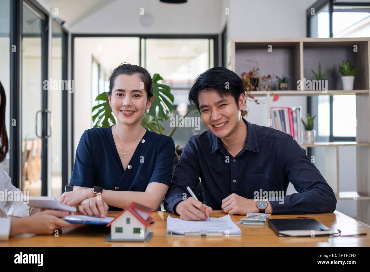 Una giovane coppia felice riceve un affare meraviglioso dopo la firma di un contratto per comprare una sede. Concetto di bene immobile. Foto Stock