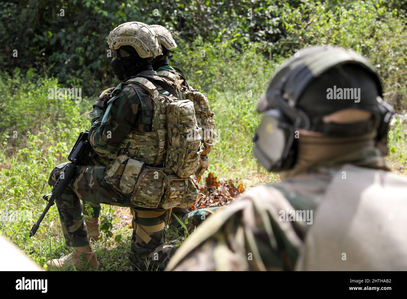 Un soldato britannico delle operazioni speciali osserva i soldati delle forze speciali del Ghana che pattugliano durante il Flintlock 2022, in Côte d'Avorio, 27 febbraio 2022. Flintlock è un esercizio multi-nazionale che consiste di 11 nazioni di formazione in Côte d'Avorio. Flintlock contribuisce a rafforzare la capacità degli alleati e dei partner di contrastare l'estremismo violento e di garantire la sicurezza regionale. (STATI UNITI Foto dell'esercito di Sgt. Kacie Benak) Foto Stock