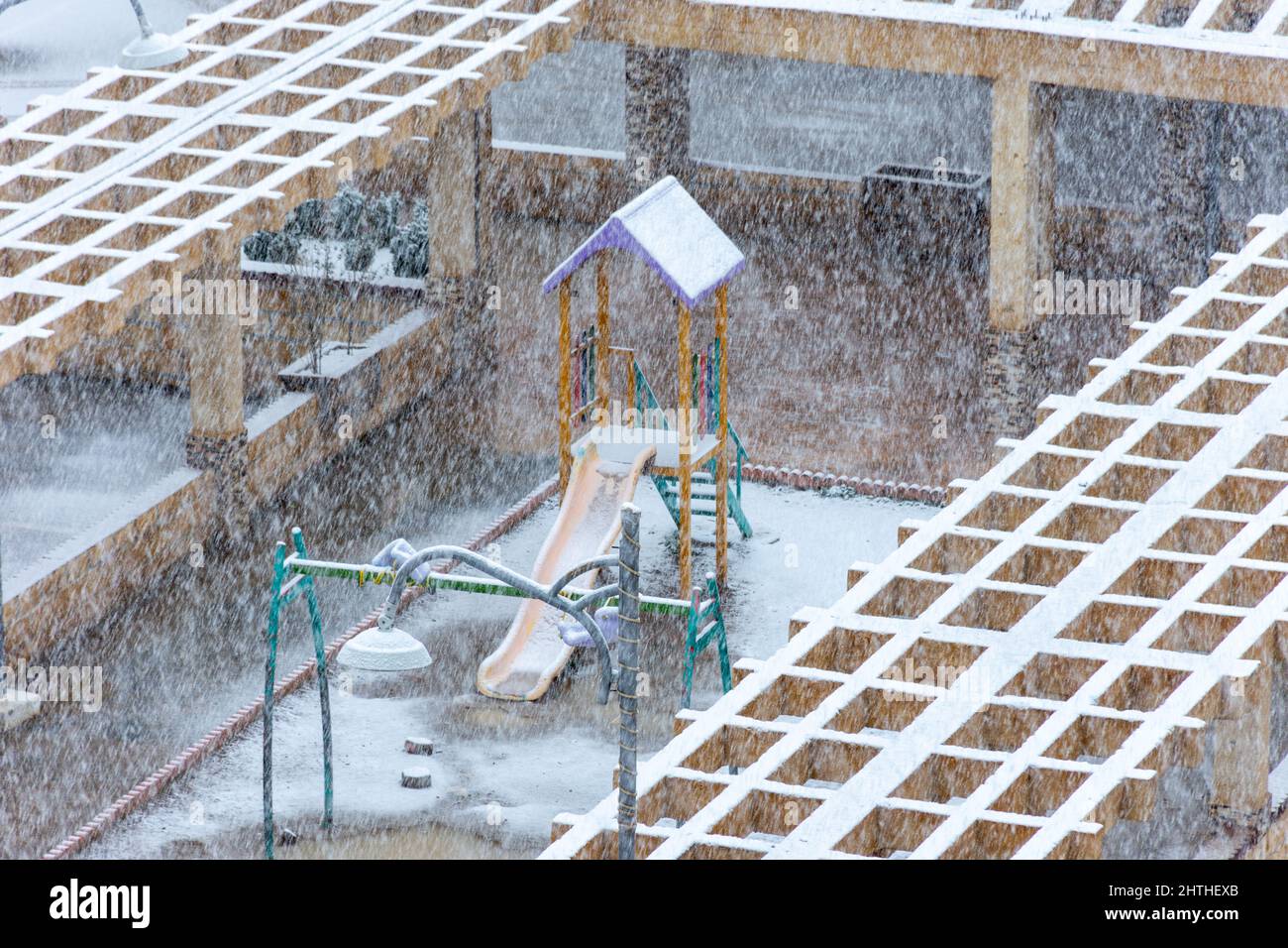 Vista dall'alto dell'area giochi per bambini sotto la neve. Parco giochi per bambini all'aperto. Foto Stock