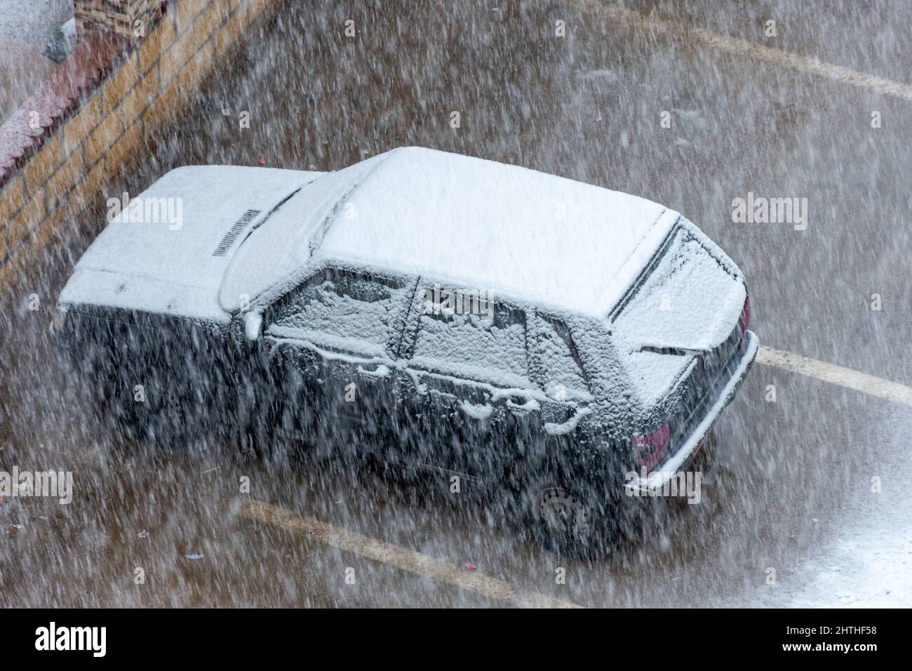 Vista dall'alto di un'auto parcheggiata sulla strada coperta di neve. Foto Stock