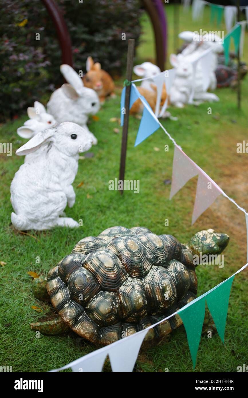 Coniglio e tartaruga replica gara su un giardino ricreativo. Foto Stock