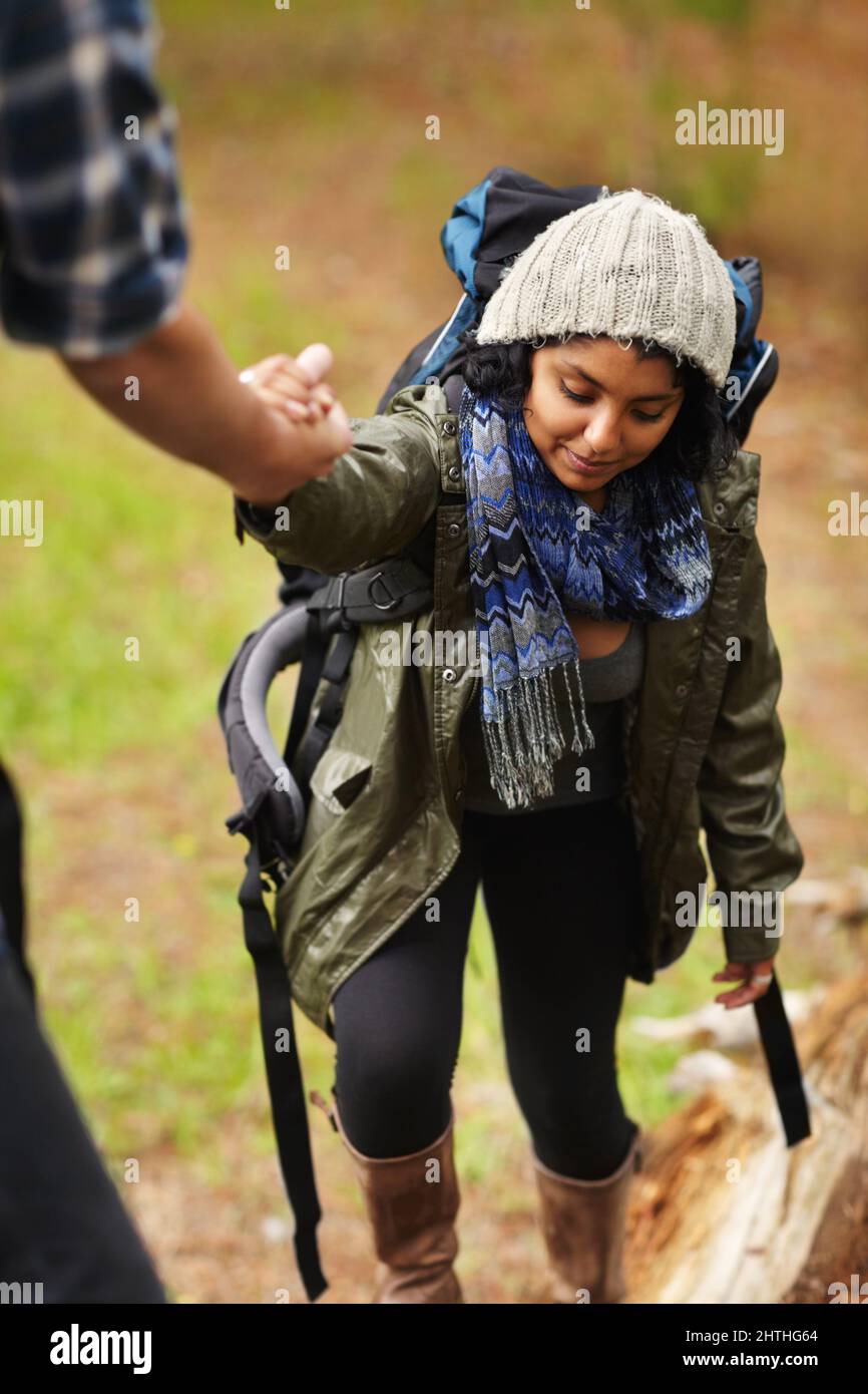 Prestare una mano d'aiuto. Giovane donna che riceve una mano di aiuto dal suo ragazzo mentre fuori escursioni. Foto Stock