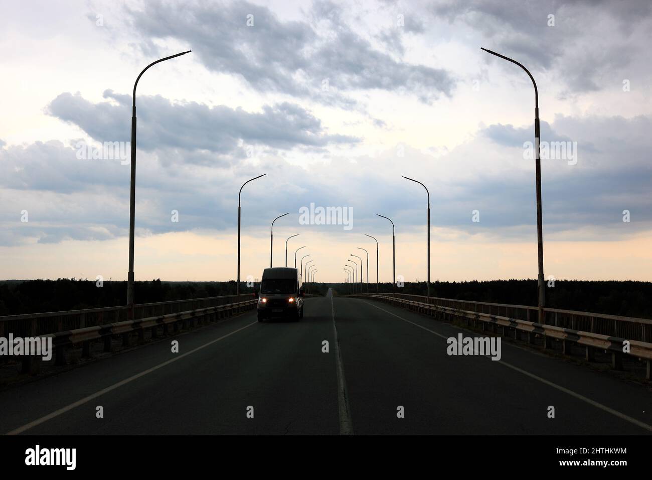 Strassenlaternen auf einer Bruecke vor grauen Abendhimmel Foto Stock