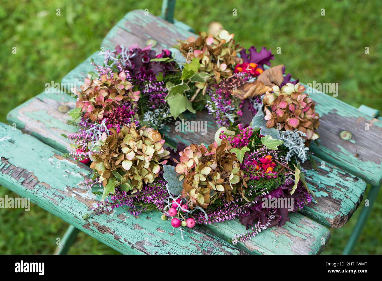 Coloratissima corona autunnale su una sedia da giardino Foto Stock