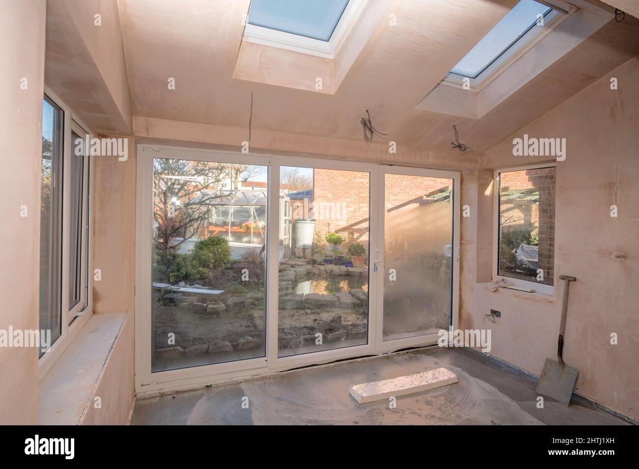 L'interno di una casa parzialmente completata estensione con una vista giardino in Inghilterra, Regno Unito Foto Stock