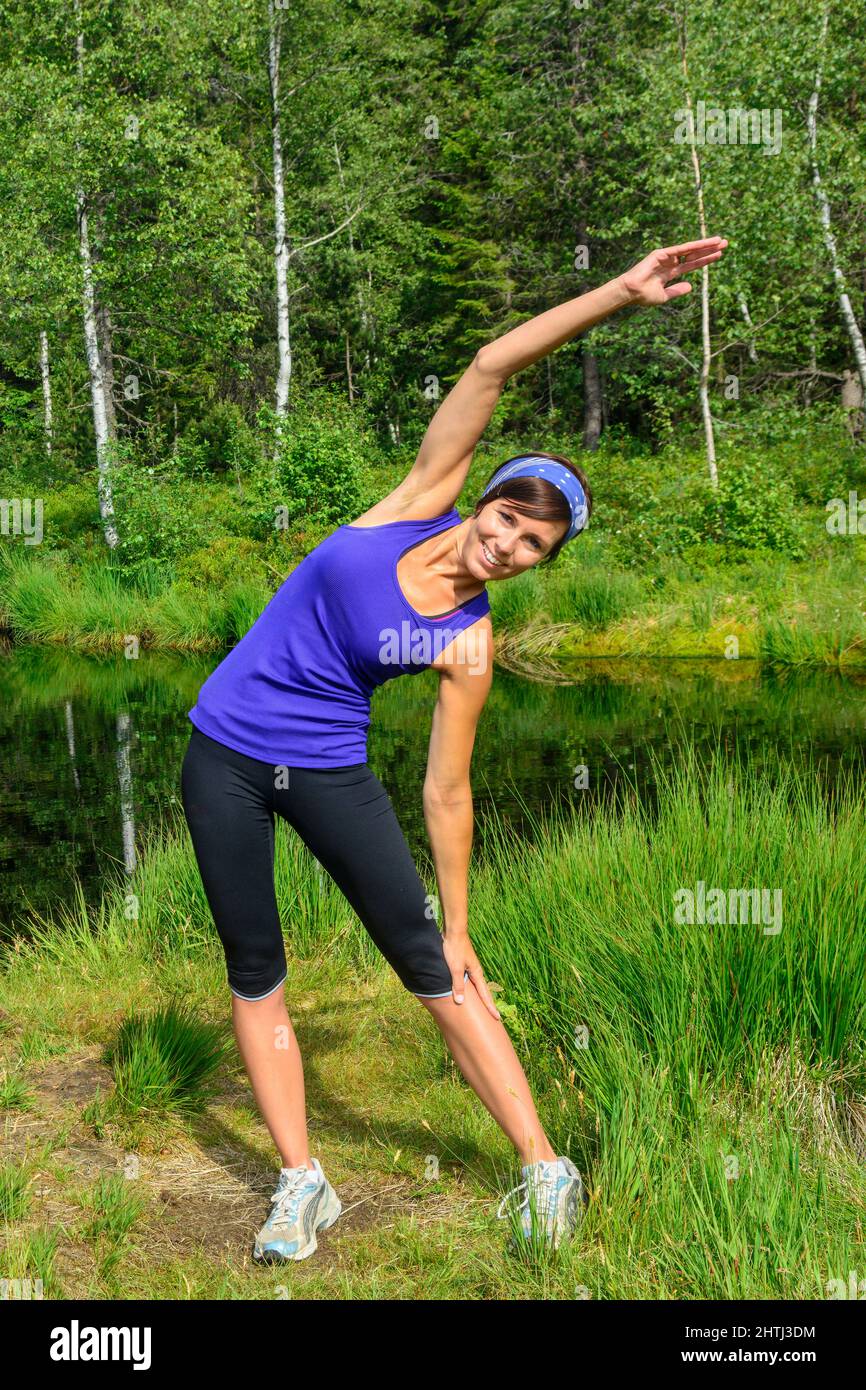 Giovane donna che fa jogging nella foresta - allenamento faticoso in estate Foto Stock