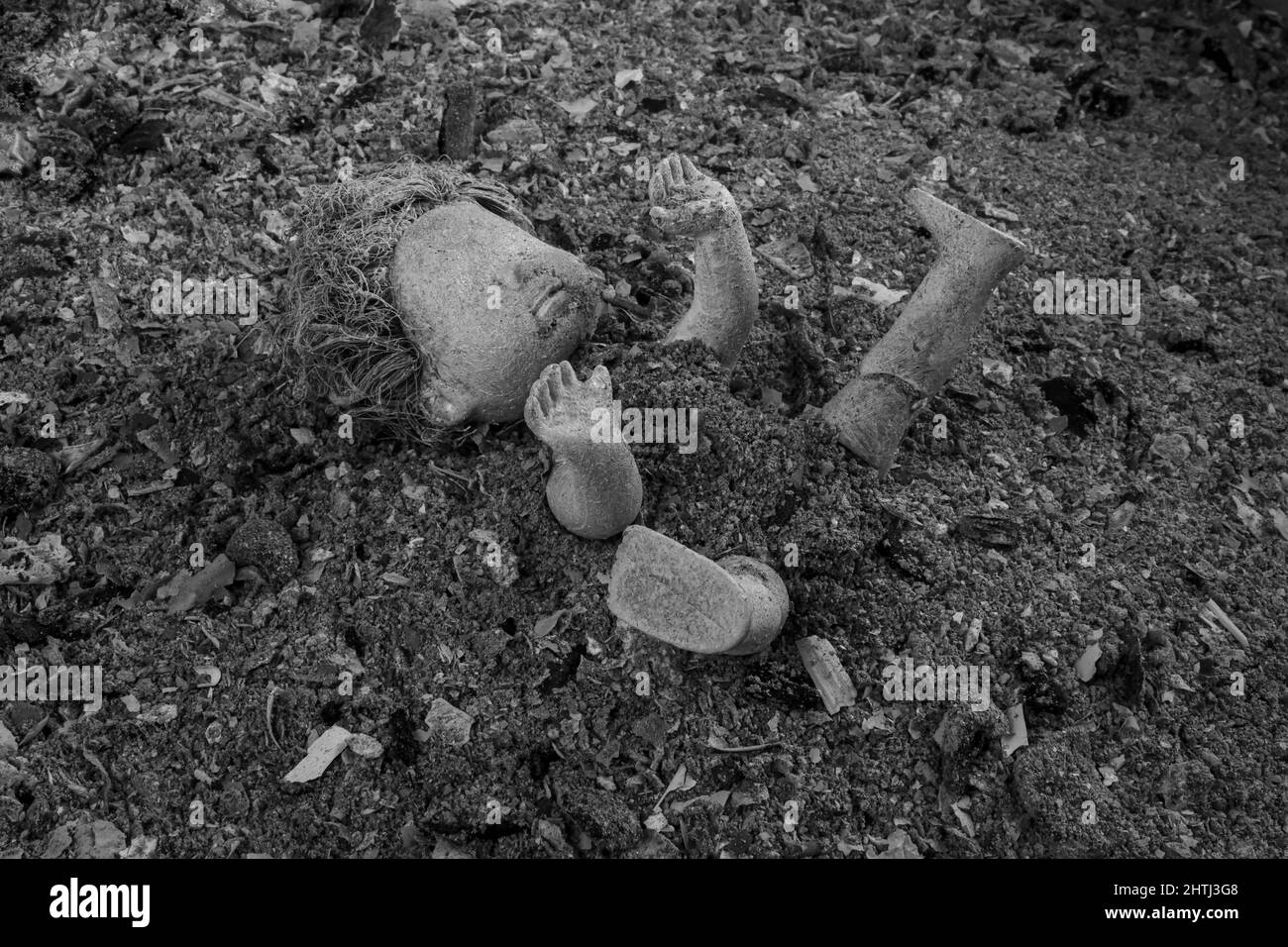 Bambola abbandonata in un mucchio di ceneri grigie. Violenza contro il concetto di popolo ucraino. Guerra, devastazione e rovine in Ucraina, 2022. Foto Stock