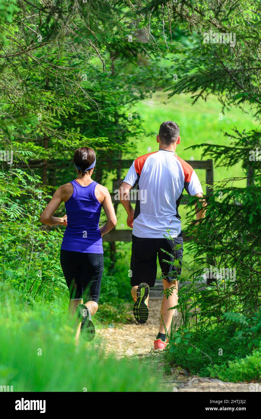 Coppia giovane jogging nella foresta - faticoso allenamento in estate Foto Stock