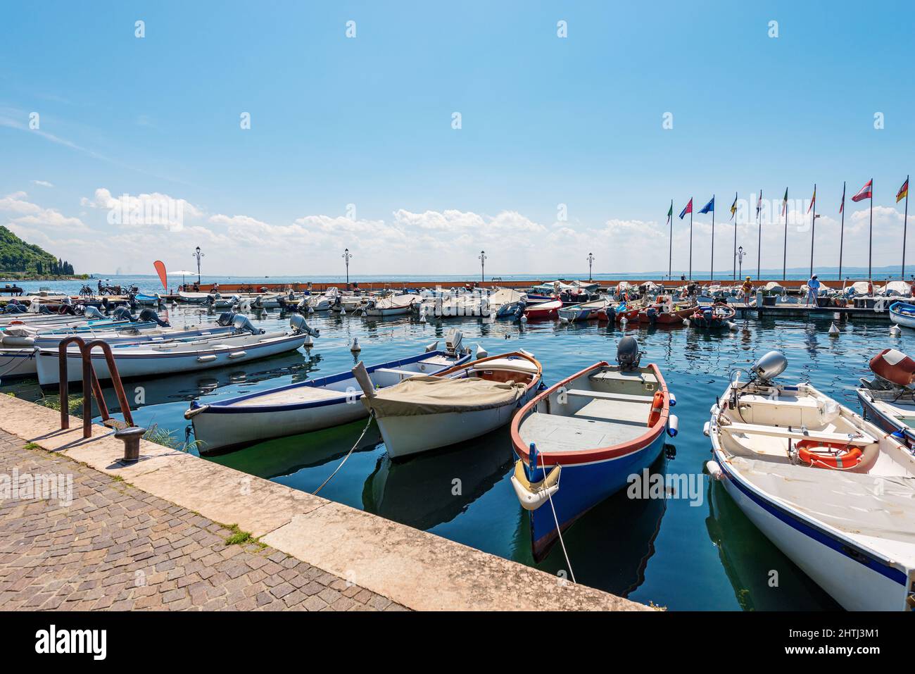 Piccolo porto del Lago di Garda. Molte barche ormeggiate, di fronte alla città di Garda, famosa località turistica in provincia di Verona, Veneto, Italia, Sud Europa. Foto Stock