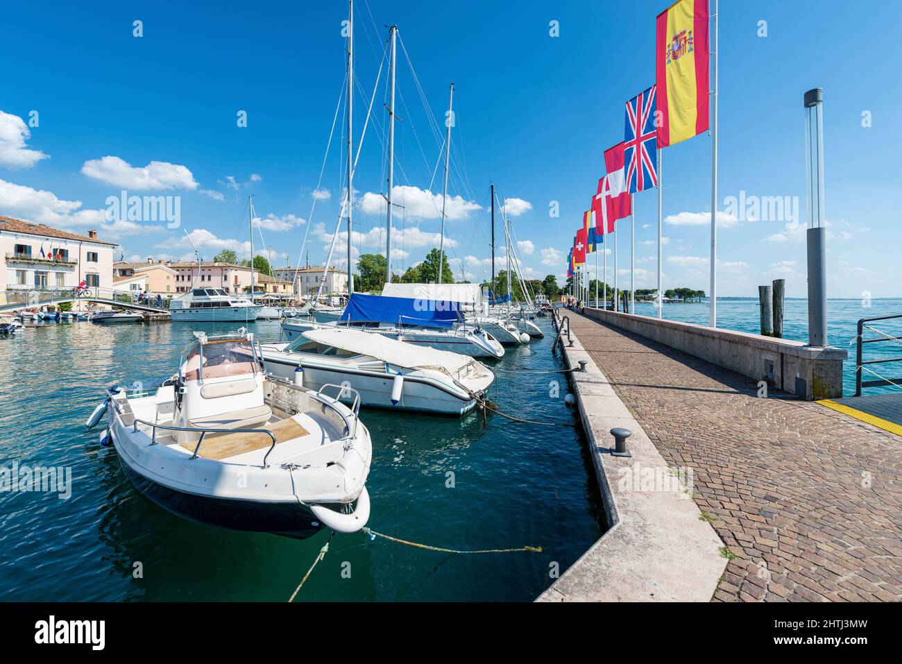 Piccolo porto del villaggio di Bardolino con piccole barche ormeggiate. Località turistica sulla costa del Lago di Garda. Provincia di Verona, Veneto, Italia, Sud Europa. Foto Stock