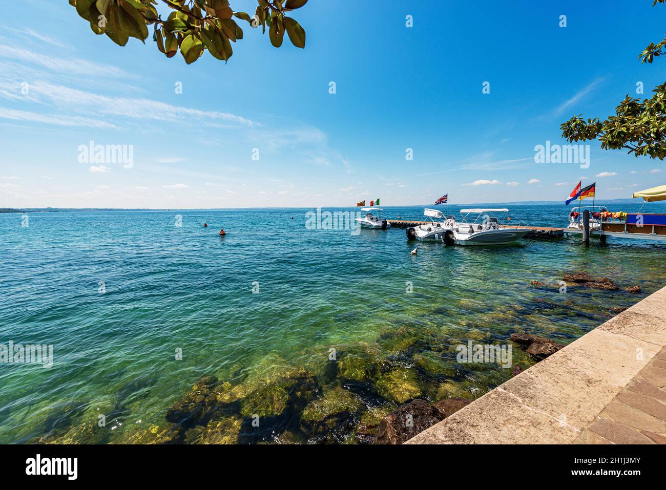 Piccole imbarcazioni a motore ormeggiate sulla costa del Lago di Garda, località di Bardolino, località turistica in provincia di Verona, Veneto, Italia, Europa. Foto Stock