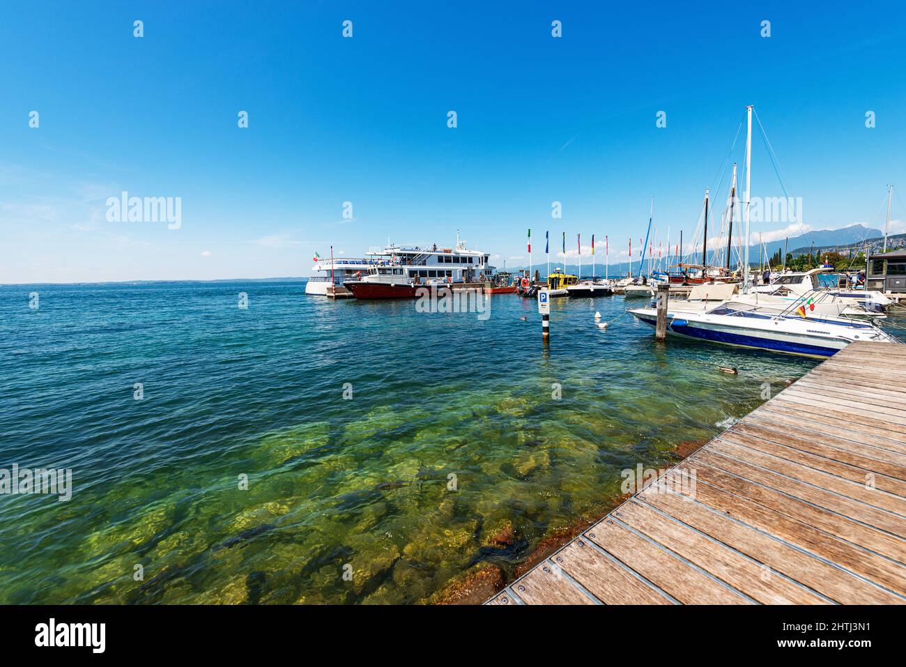 Porto con traghetto stazione del villaggio di Bardolino con molte piccole barche ormeggiate. Località turistica sulla costa del Lago di Garda. Provincia di Verona, Italia. Foto Stock