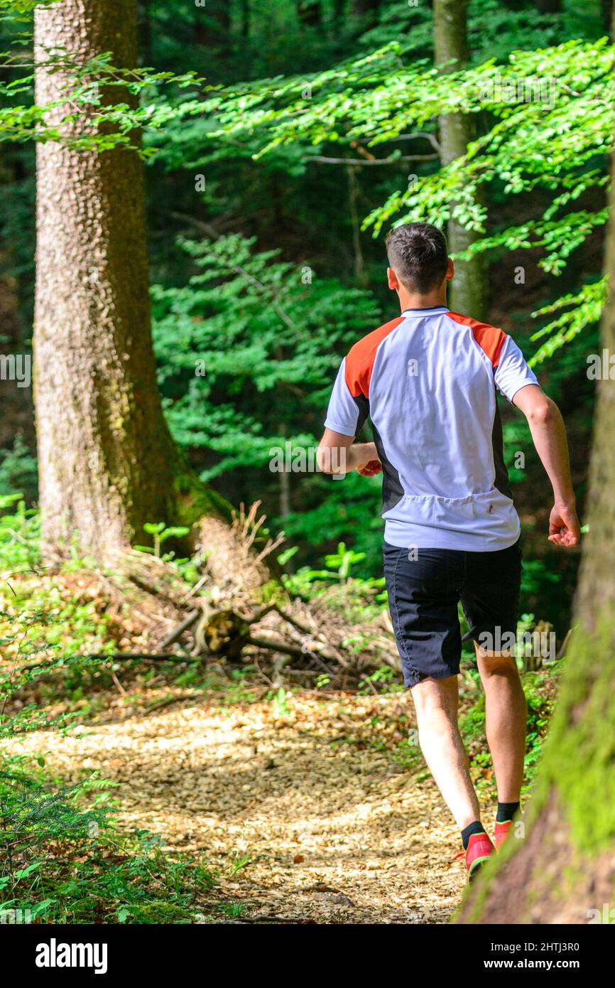 Coppia giovane jogging nella foresta - faticoso allenamento in estate Foto Stock