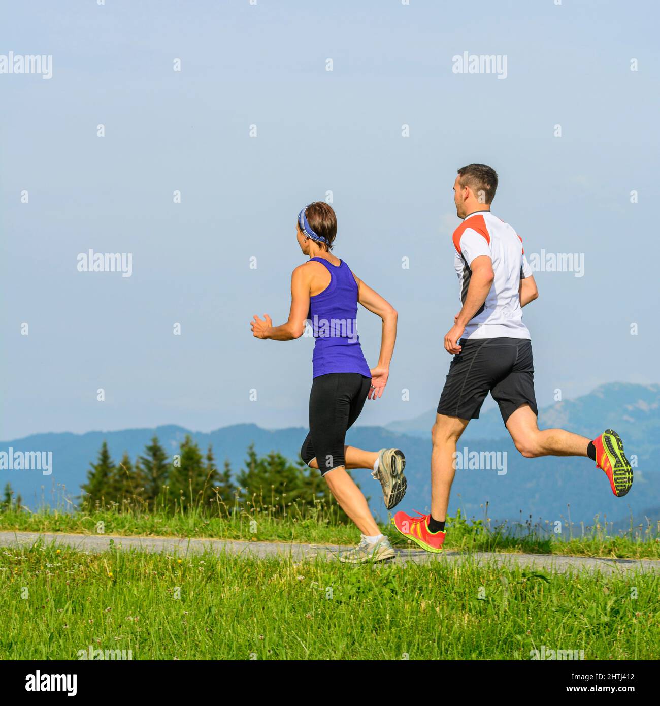 Coppia giovane jogging nella foresta - faticoso allenamento in estate Foto Stock