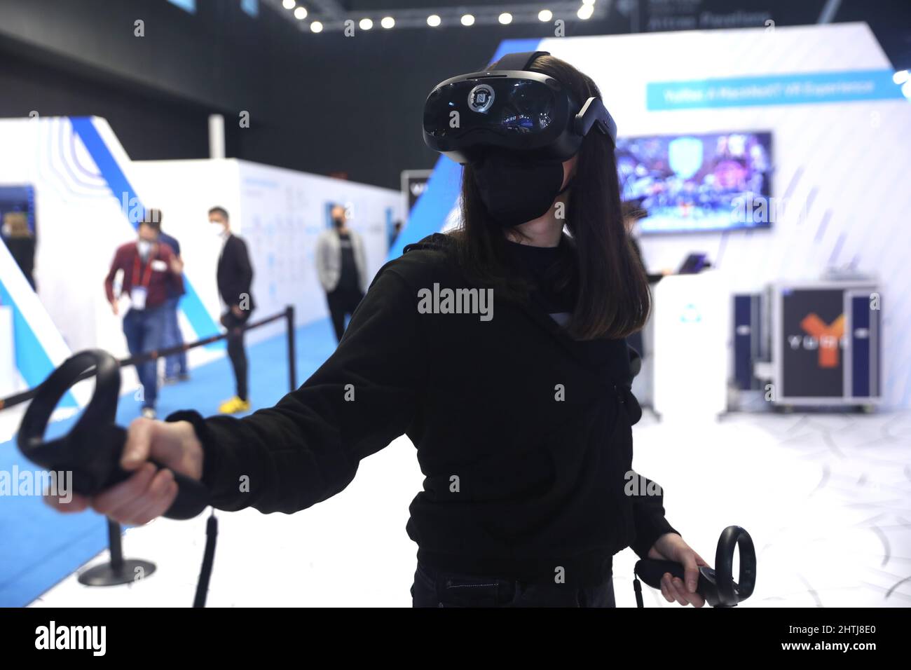 Barcellona, Spagna. 28th Feb 2022. Un membro dello staff indossa cuffie per realtà virtuale durante il Mobile World Congress (MWC), la fiera annuale organizzata dalla GSMA alla Fira de Barcelona, Spagna. Foto Stock