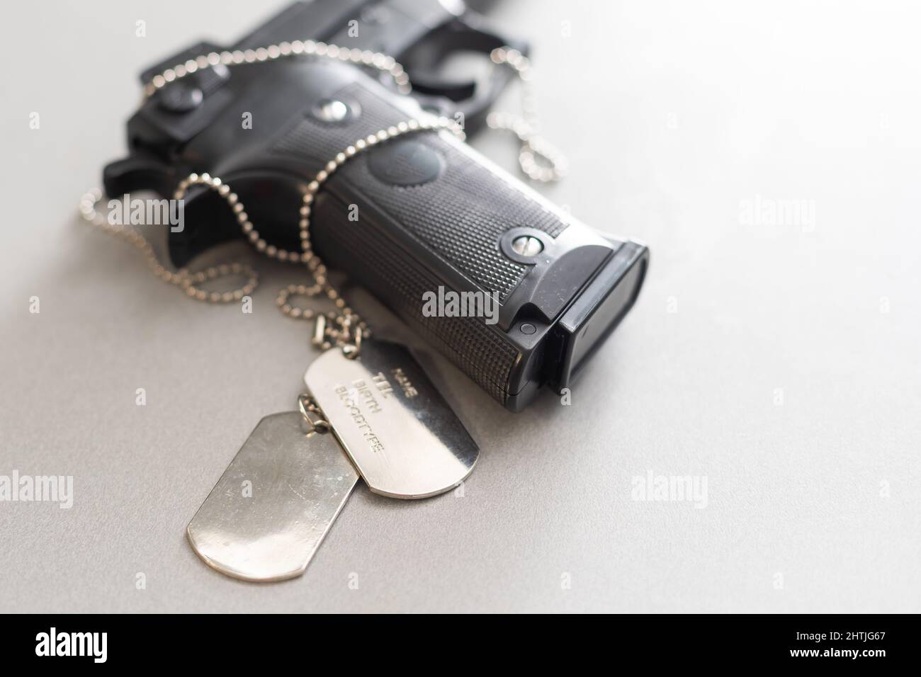 Pistola su tavolo, pistola con tag cane Foto Stock