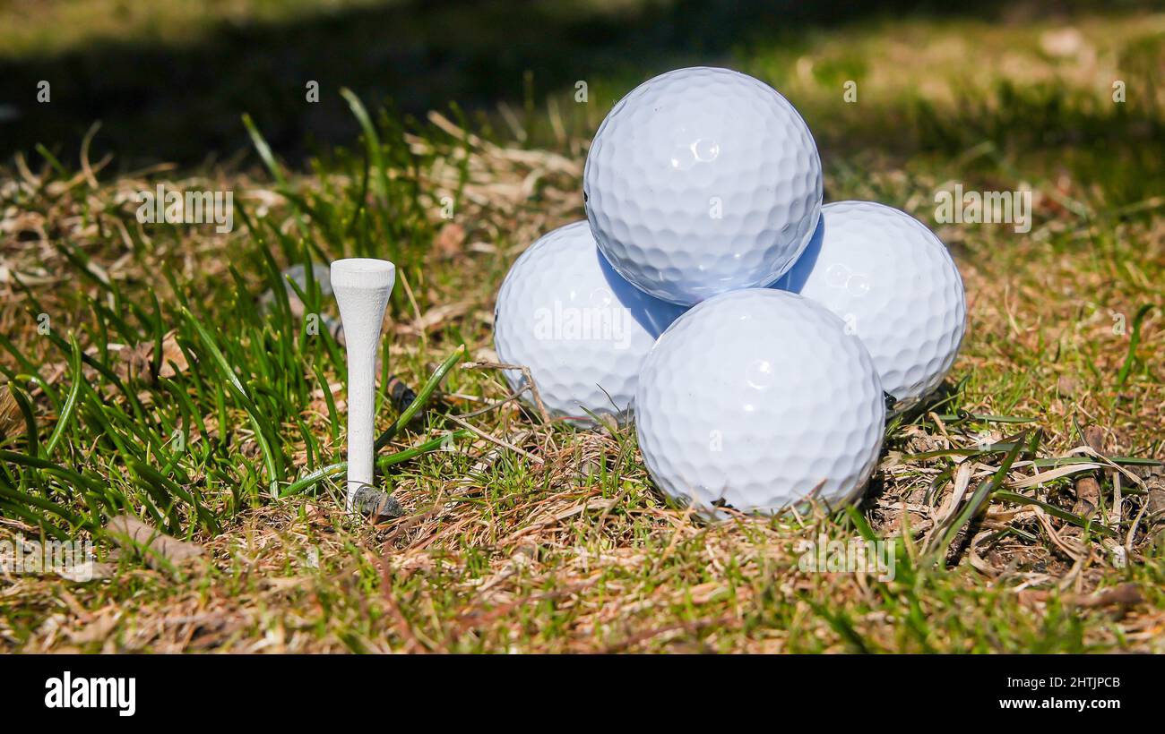 Palline da golf bianche con tee uniforme all'esterno Foto Stock