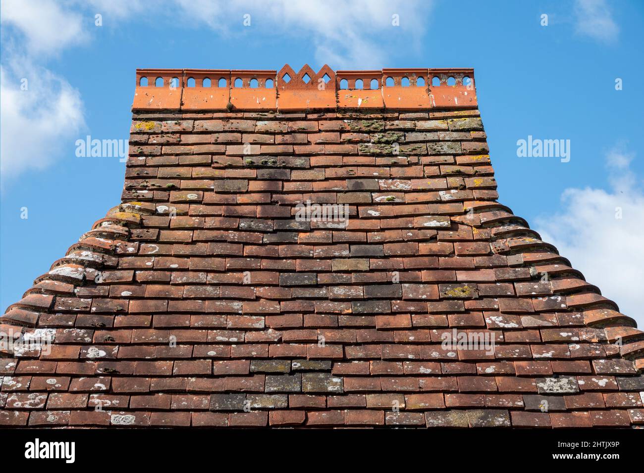 Tetto piccolo con tegole di cresta forate e bordi arrotondati in argilla rossa sulla Chiesa di East Hoathly Lych Gate, East Sussex Foto Stock