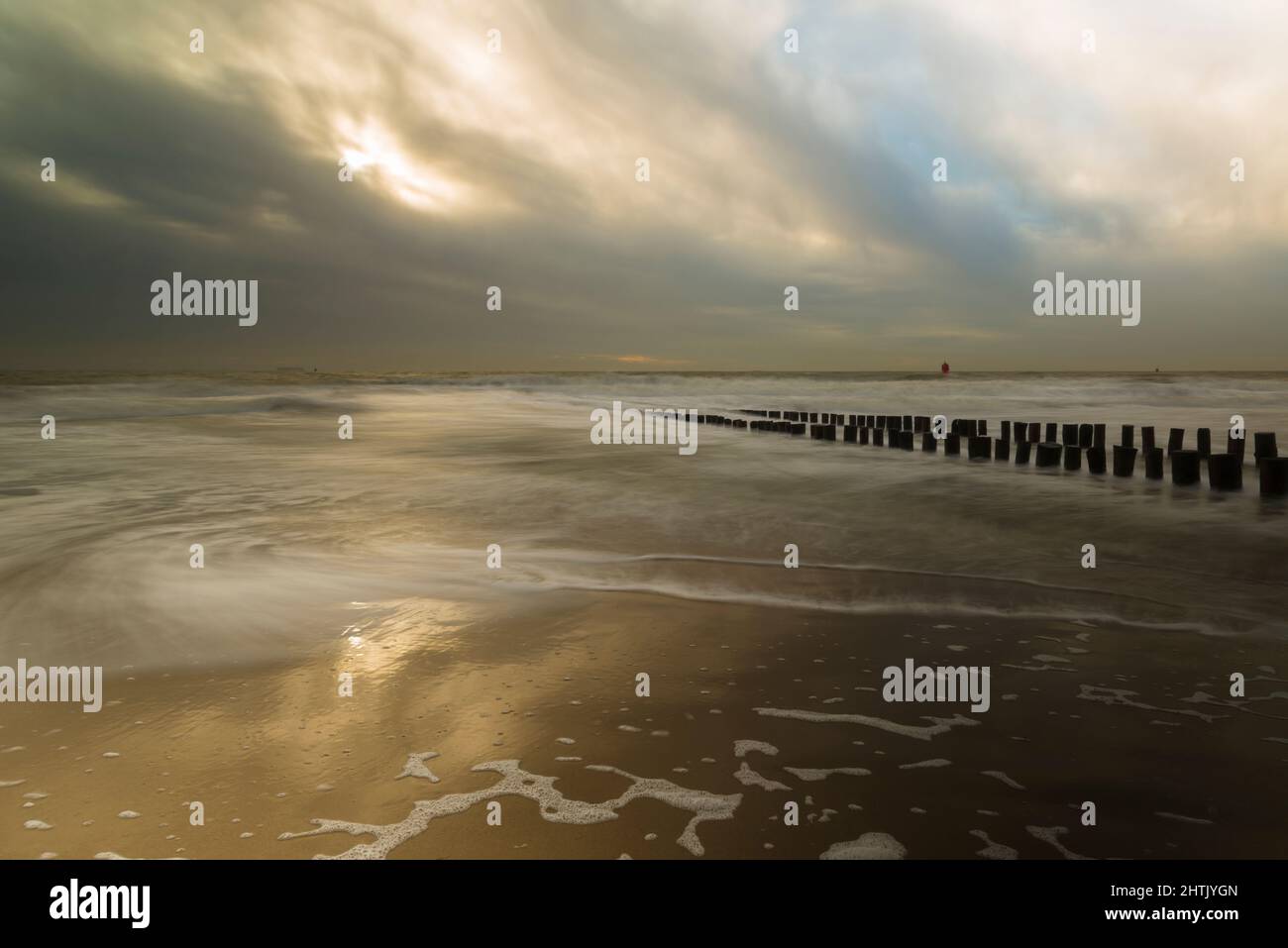 Foto lunga esposizione di un frangiflutti di legno sulla costa di Zeeland, Paesi Bassi Foto Stock
