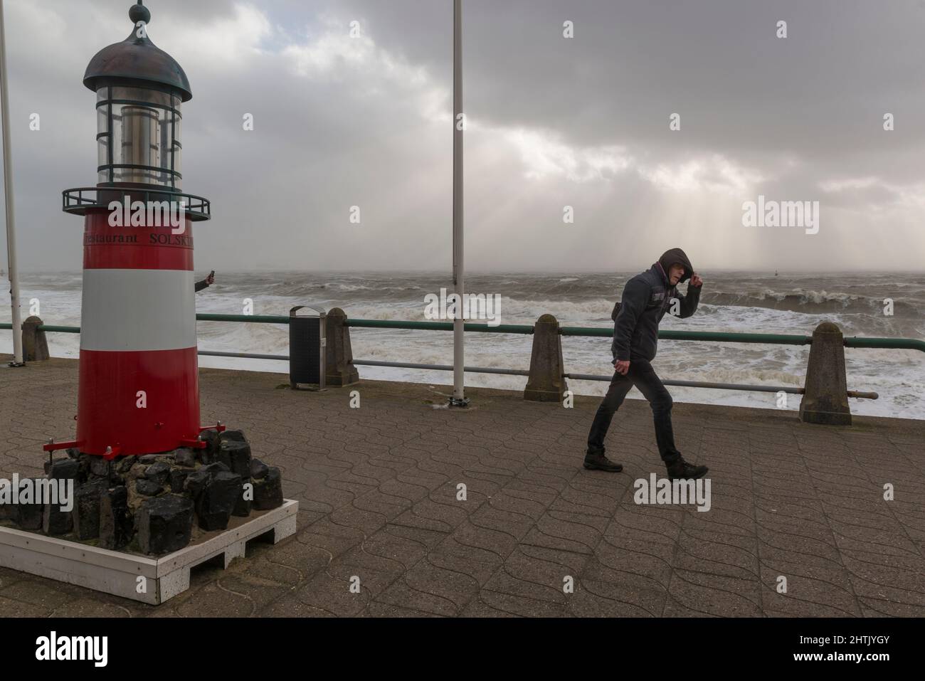 Uomo che affronta l'intensa tempesta Eunice sul viale di Vlissingen, Zeeland, Paesi Bassi Foto Stock
