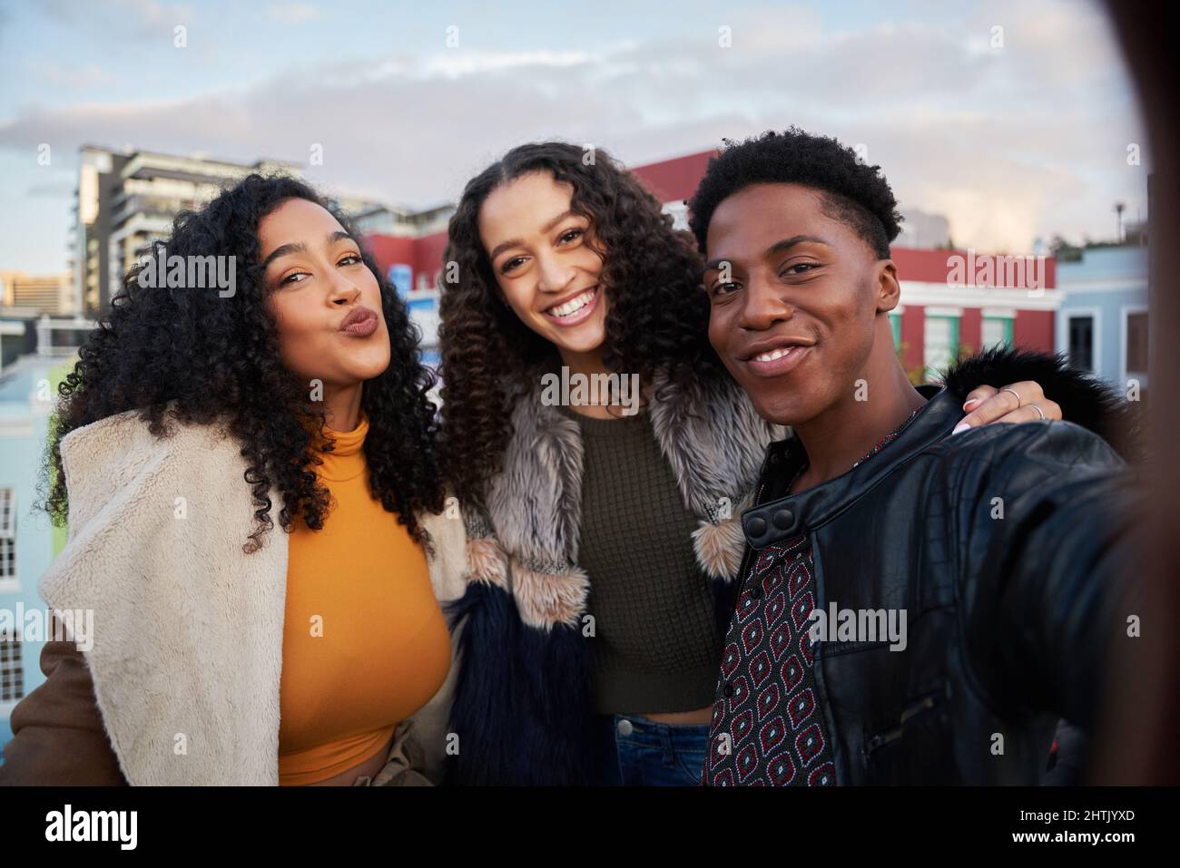 Gruppo di amici diversi che prendono selfie al party sul tetto. Posa per la macchina fotografica, felice e ridendo nello stile di vita della città Foto Stock