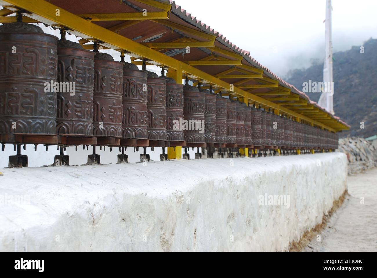 Vista delle ruote buddiste di preghiera sulla base campo trekking verso le montagne Foto Stock