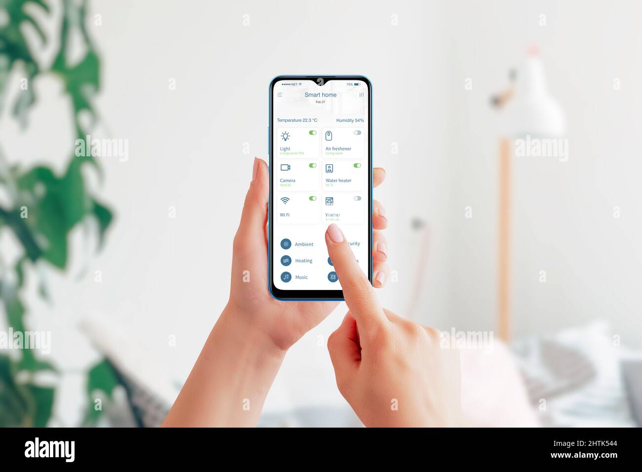 Controlla i dispositivi domestici con l'app Smart Home. Smartphone nelle mani, interno del soggiorno sullo sfondo. Interfaccia moderna per le app di automazione domestica Foto Stock
