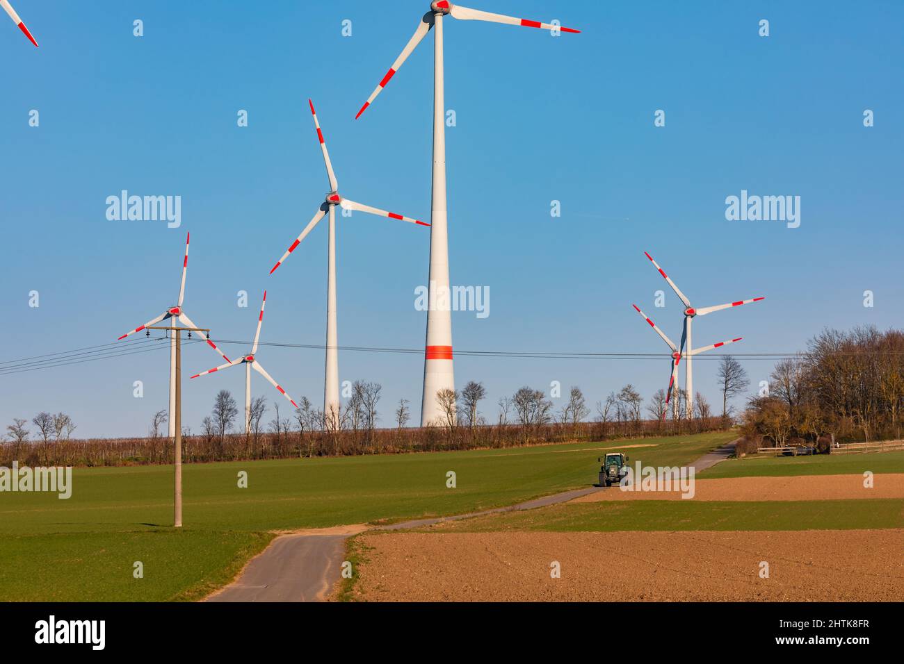 Agricoltura accanto a enormi turbine eoliche Foto Stock